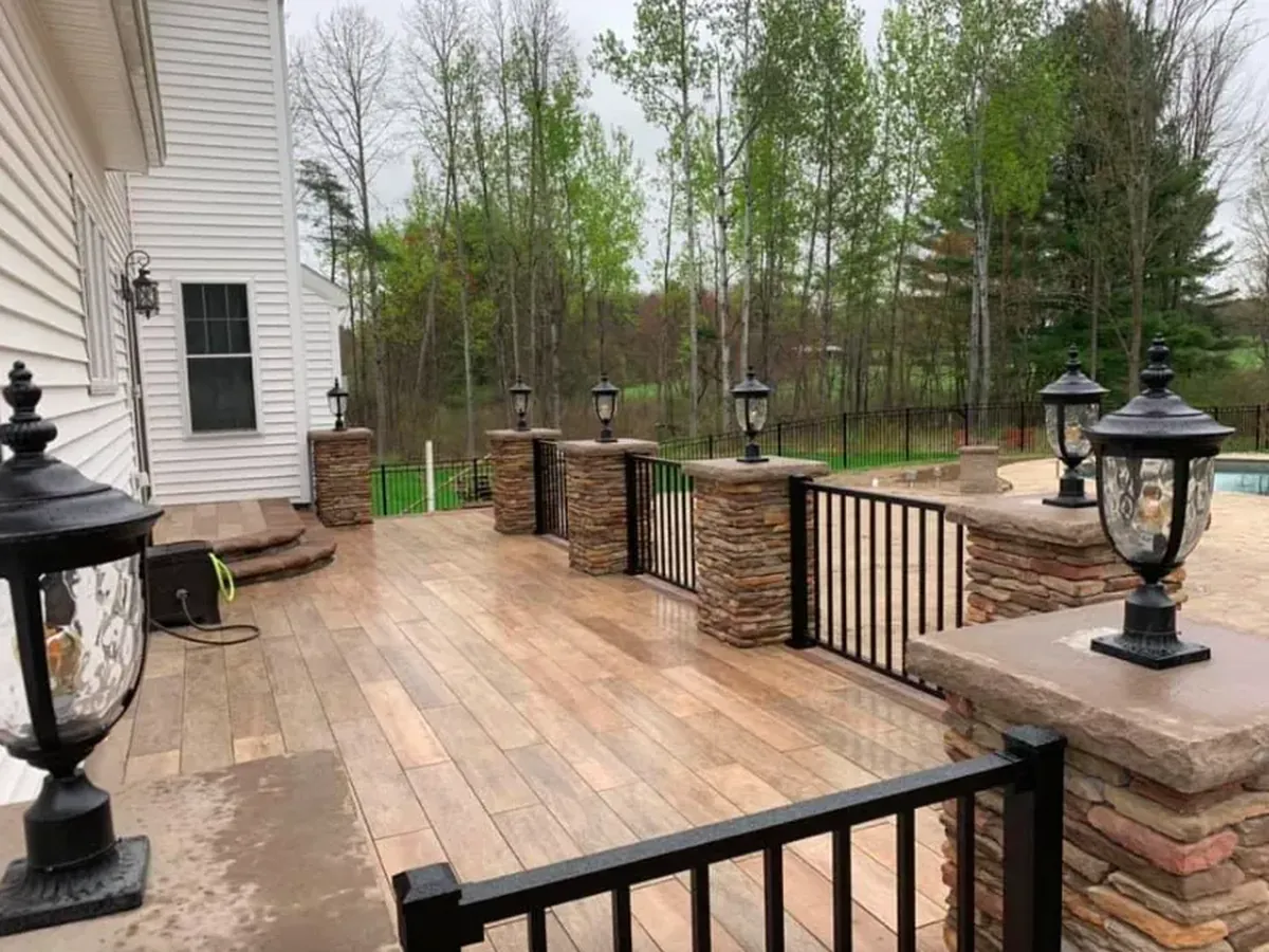 Custom landscape design and full backyard hardscape with pool and outdoor kitchen in Guilderland NY